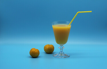elegant vintage glass of orange juice, drinking straw and quince fruits 