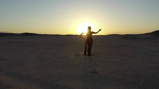 Aerial drone shot following a bellydancer in Egyptian desert