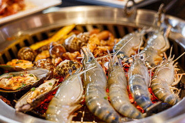 Pork , shrimp and mussels on grilled over charcoal stove. Korean barbecue or yakiniku style.