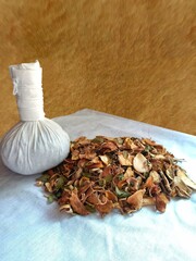 Ingredients of herbal compress ball with rough blurred wooden background