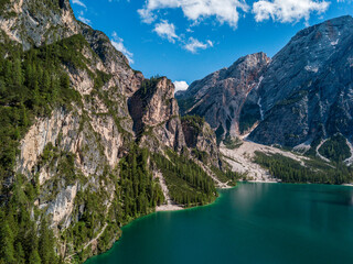 Naklejka na ściany i meble Aerial view of the Lake Braies, Pragser Wildsee is a lake in the Prags Dolomites in South Tyrol, Italy. People walking and trekking along the paths that run along the lake