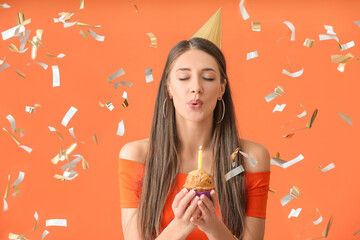 Young woman celebrating birthday on color background