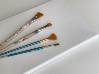 Brushes and clear canvas on the white table.  Artist, art and hobby. Drawing and painting. 