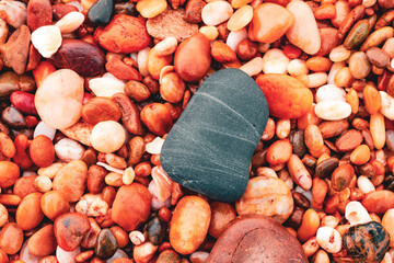 Des gros et des petits cailloux de couleurs différentes sur la plage .
