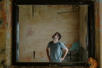 Young man observing old and abandoned place