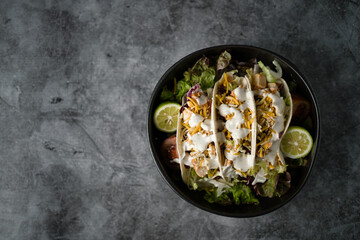 Chicken tacos with salad on a dark background. Top view.