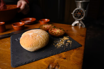Plano de la elaboración de receta casera con carne fresca cruda de ternera, especias, tomate, pan y herramientas de cocina