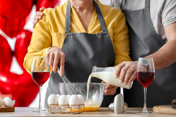 Mature couple celebrating Valentine's Day while cooking festive dinner
