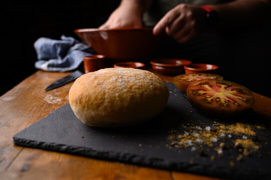 Primer plano de pan y tomate con especias en la elaboraci&oacute;n de receta casera ene bol de barro