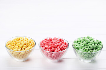 Various corn rings in glass bowls on white wooden table