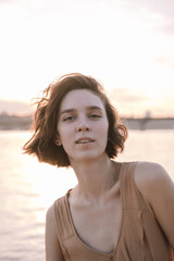 young woman posing and yoga dancing near beach at sunset