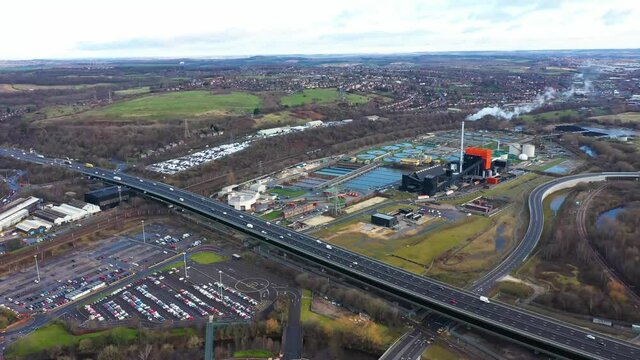 Aerial footage of a a sewage treatment plant and motorway located in Sheffield in the UK along side the M1 motorway showing the recycling seperation water tanks