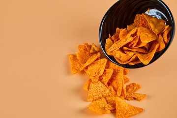 Bowl of crispy chips on orange background