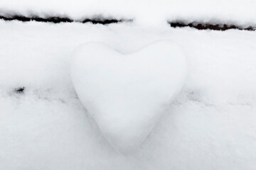 Fototapeta premium A snow-white heart made of snow on a bench. The Concept Of Valentine's Day