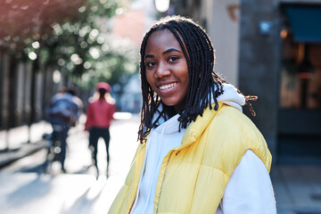 Young woman smiling while standing outdoors.