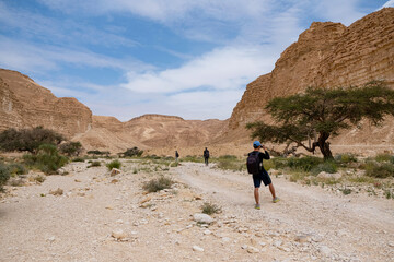 Fototapeta na wymiar people hiking on a rocky valley on deset.