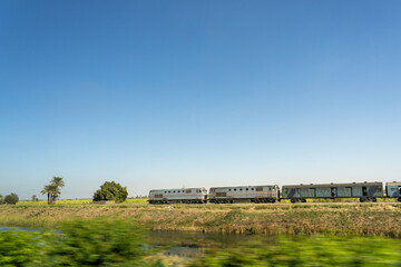 A train running at speed with two sides of the river and the meadow