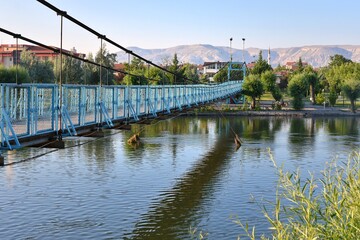 Beautiful steel bridge over the Kizilirmak River in Avanos Town, Turkey. View of the river and old city with a mosque in Avanos, central Anatolia
