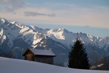 Beautiful view to the alps in winter with a hut in the foreground