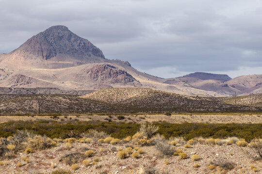 Rolling hills and small mountain behind vast desert vista landscape in rural New Mexico