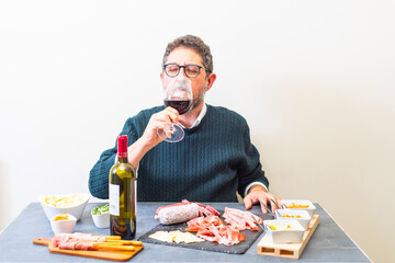 caucasian man at table glasses of red wine, appetizer aperitif
