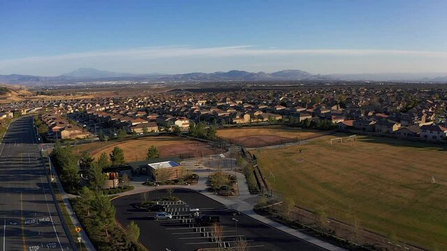 Panning aerial shot above recreation center and athletic fields in a desert master-planned community. HD at 60 FPS.