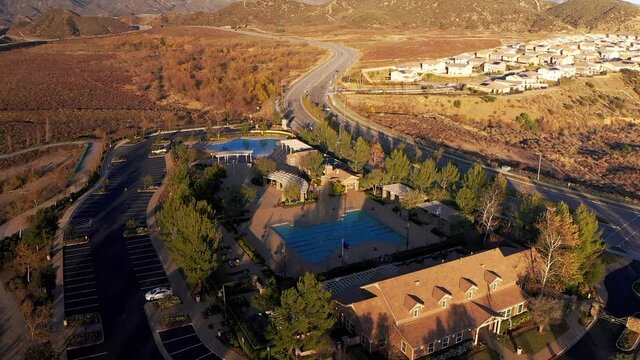 Aerial reverse pull-back shot of a community pool in a master-planned community in the desert. HD at 60 FPS.