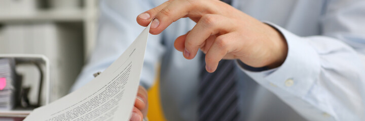 Obraz premium Cropped photo of young businessman holding a pen and signing a document in office