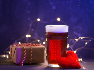 Valentine's day surprise, a glass of craft red beer on the table, gift boxes.