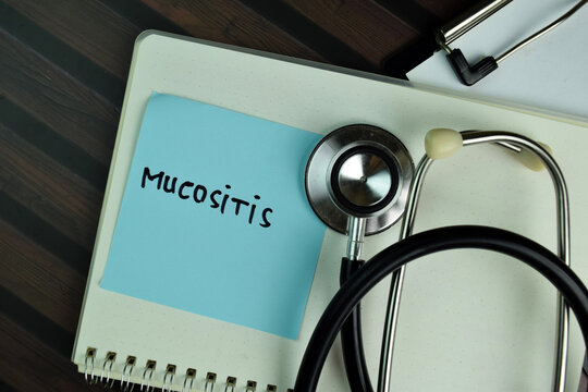 Mucositis write on sticky notes write on a sticky notes isolated on Wooden Table.