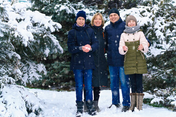 family portrait in the winter forest, parent and children, beautiful nature with bright snowy fir trees