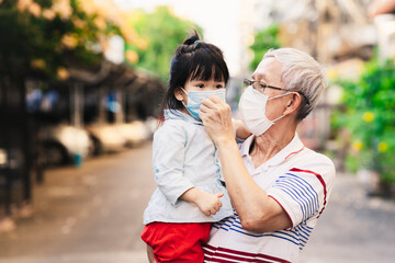 Grandpa wear face mask to kids for protect corona virus pandemic  outside home. Family always use...