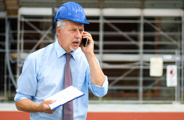 Angry senior engineer shouting at the phone