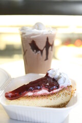 cherry cheesecake on a black background with reflection and flying icing sugar milkshake behind