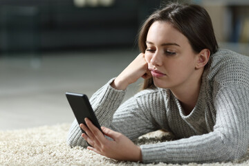 Bored teen checking smart phone at home