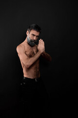 Fototapeta na wymiar guy with a beard with a sports figure, with a naked torso on a black background