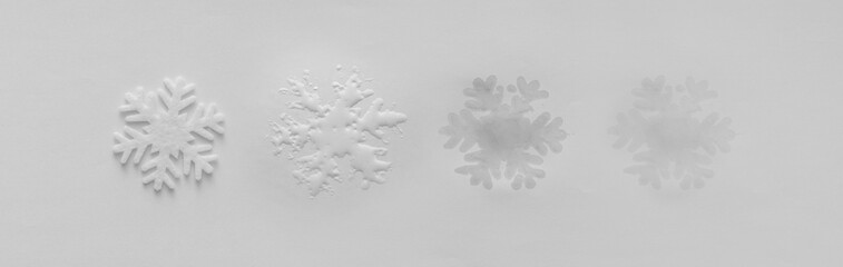 Global warming and environmental change shown by melting snowflake leaving fading wet print....