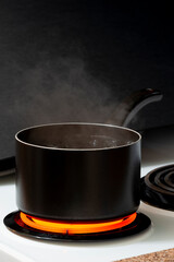 Water Boiling In Black Pot On Top Of Stove