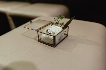 wedding rings lie in a jewelry box. decorative box with rings lying on a wooden background. wedding day. rings lying on a white flower