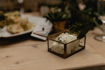 wedding rings lie in a jewelry box. decorative box with rings lying on a wooden background. wedding day. rings lying on a white flower