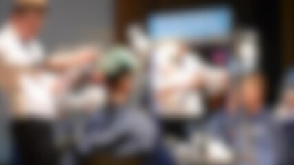 Blurred background. Male hairdressers making hair girl model close-up