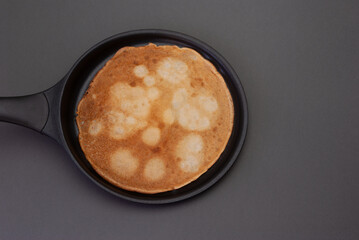A delicious looking pancake cooking in a pan