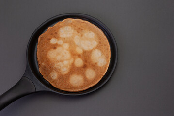 A delicious looking pancake cooking in a pan