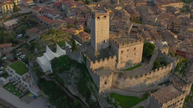 Slow aerial, reveal shot of the Castello Scaligero castle located near lake Garda, Italy