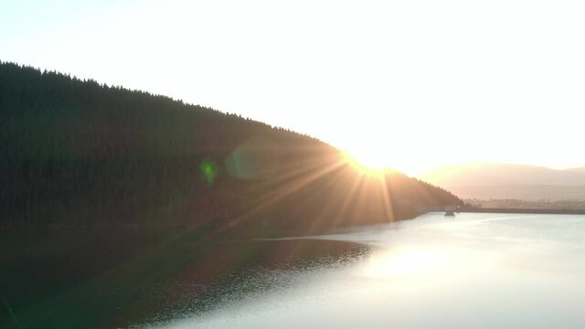 Aerial shot, Frumoasa Dam Romania with bright sunset and lens flare