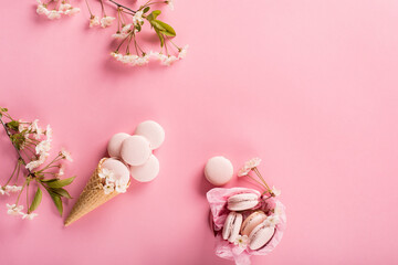 Rose macaroons in gift box and Cherry blossoms. Sweet macarons present on pink background. © Iuliia Metkalova