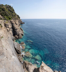 Cliff plunging into blue ocean in portofino italy. Spring and Summer holiday vacation concept.