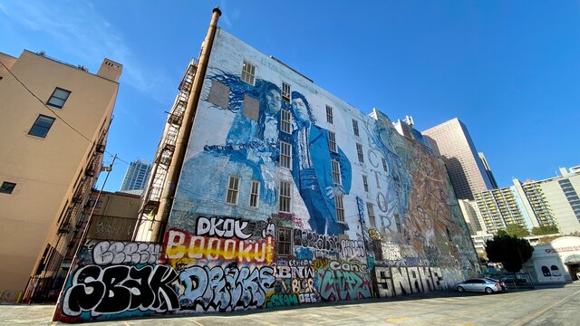 LOS ANGELES, CA, NOV 2020: Looking Up At Artistic Mural Partially Covered In Graffiti Tags On A Building Wall Next To A Parking Lot In Downtown