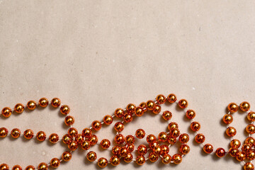Background from beige craft paper, bottom orange round beads to decorate the Christmas tree.