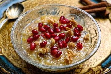 Ashure or Noah's pudding, the turkish dessert porridge in glass bowl on golden dish